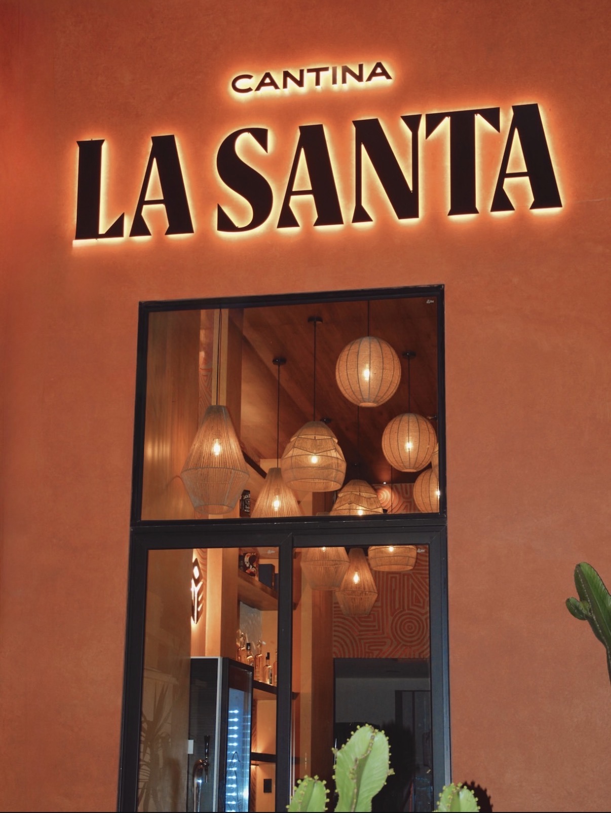 Fachada de Cantina La Santa con letrero retroiluminado